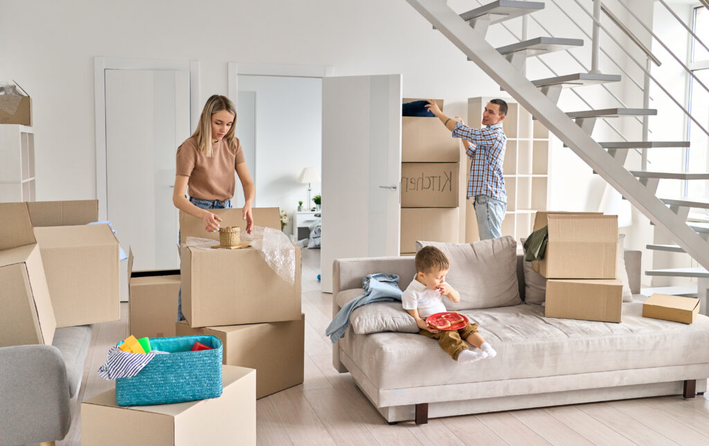 Young family with kid unpacking boxes in new apartment after renovation